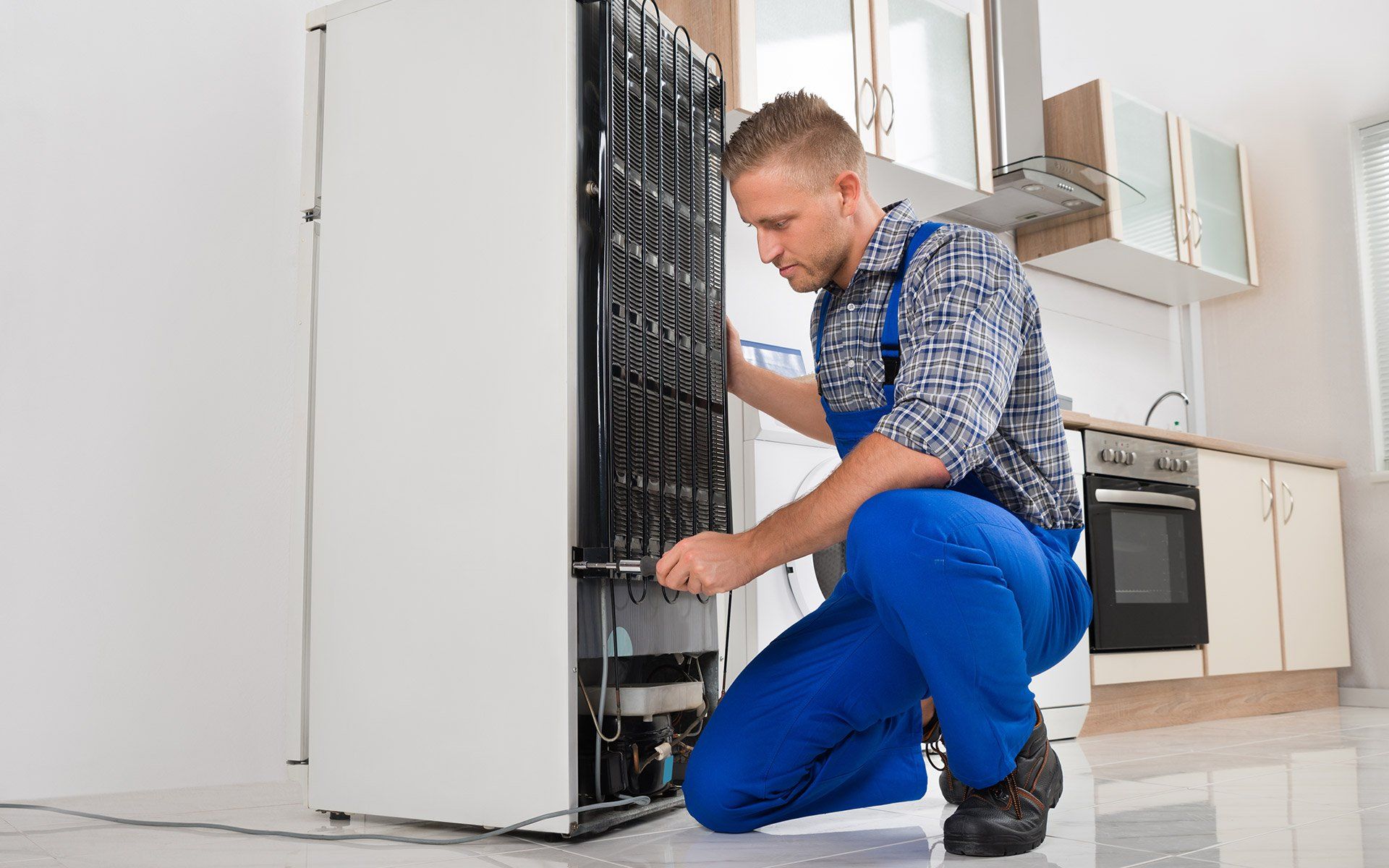 Man Fixing Refrigerator — Fairdale, KY — A + Appliance Repair